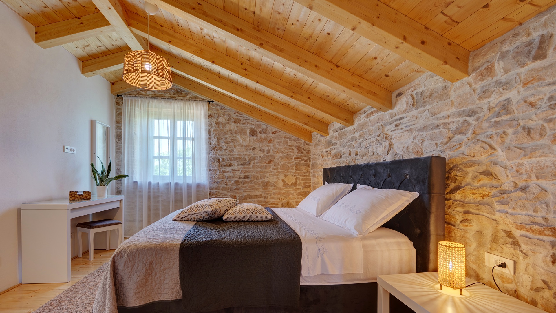 Bedroom 1 — king bed with stone wall & beams
